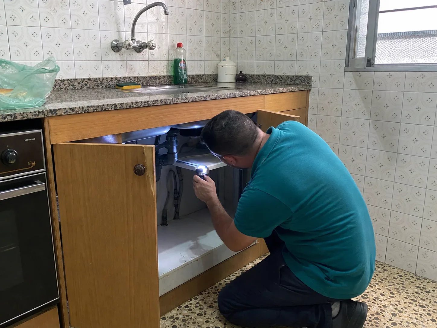 Técnico de BagesPlagas inspeccionando una cocina con linterna